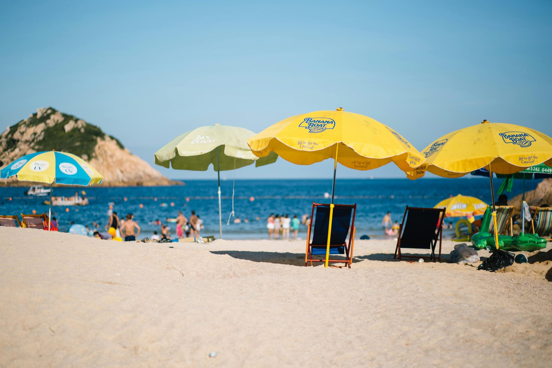 A scenic beach view featuring vibrant umbrellas and people enjoying the seaside.