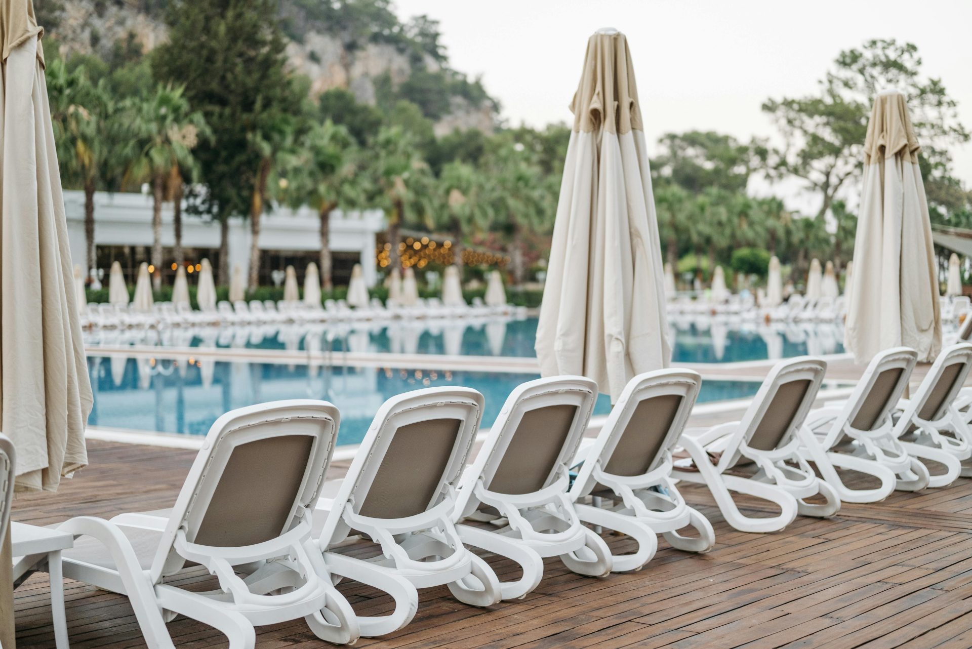 Elegantly lined sun loungers by the resort's poolside, creating a serene vacation vibe.